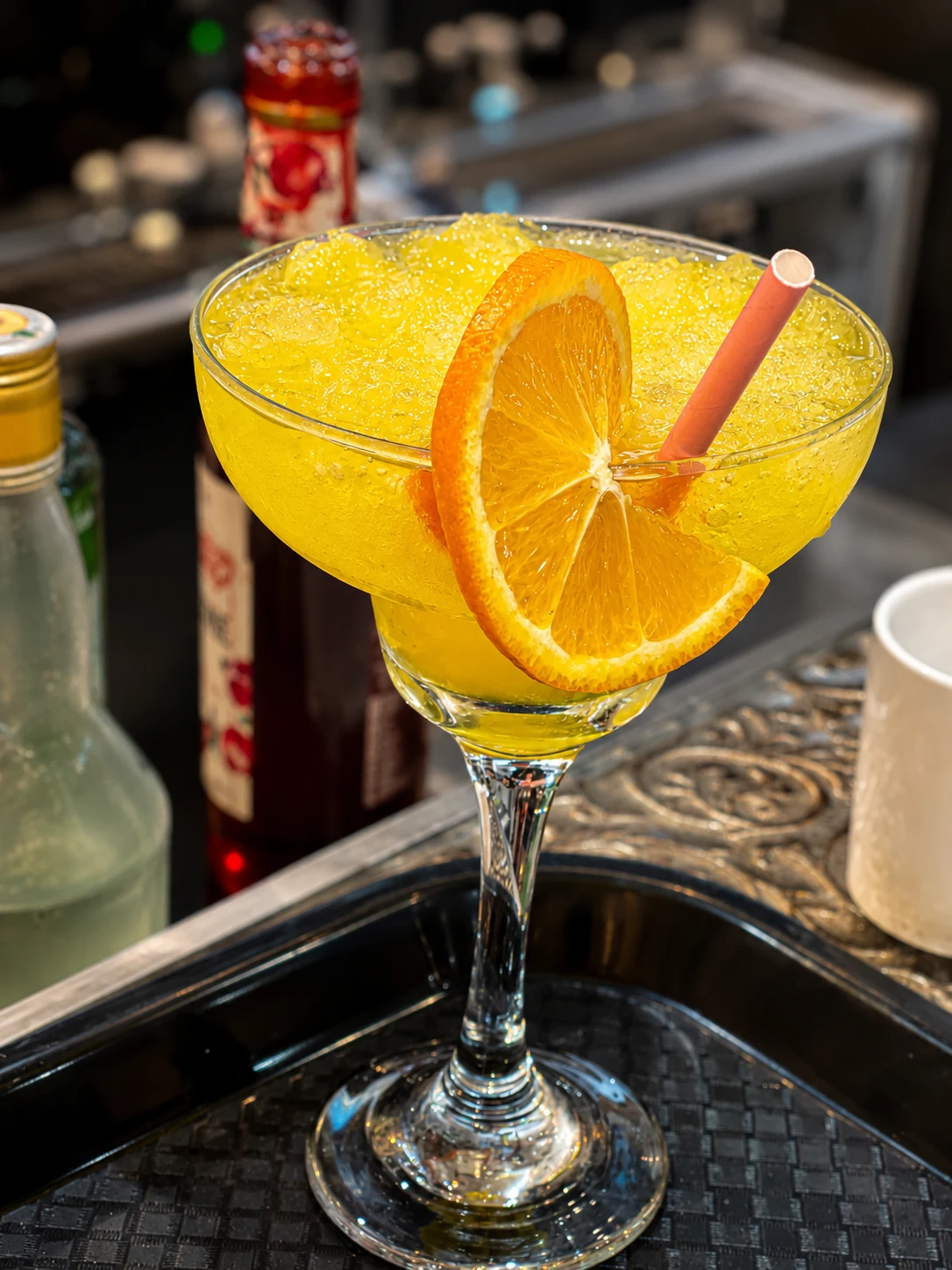 Yellow citrus cocktail with orange garnish