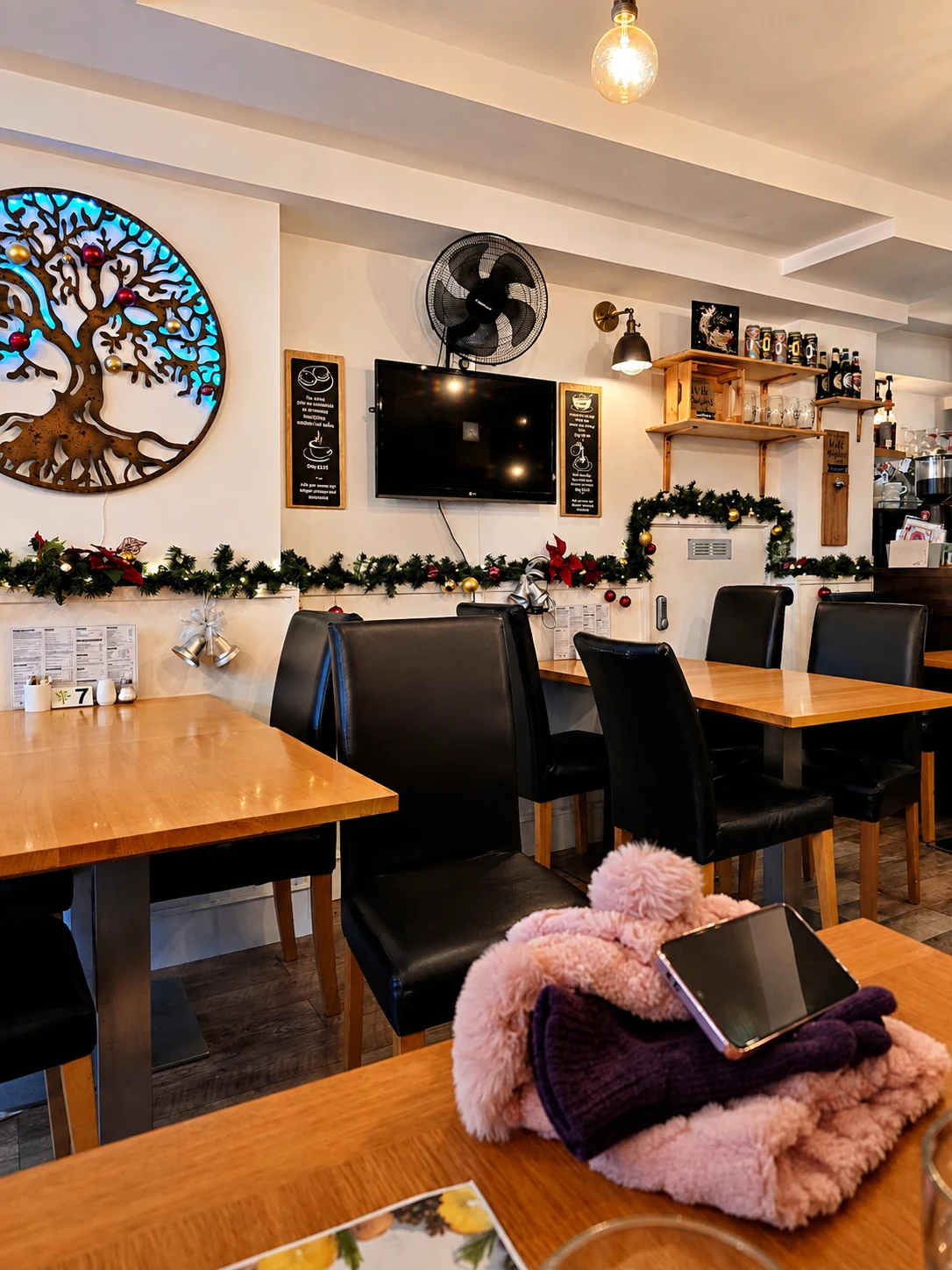 The Heavy Tree dining room with tree wall art and wooden tables